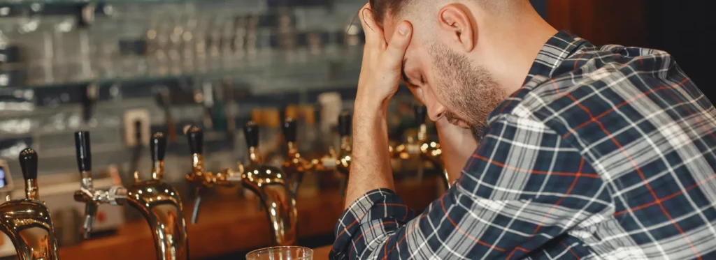 man with hands in head at the bar